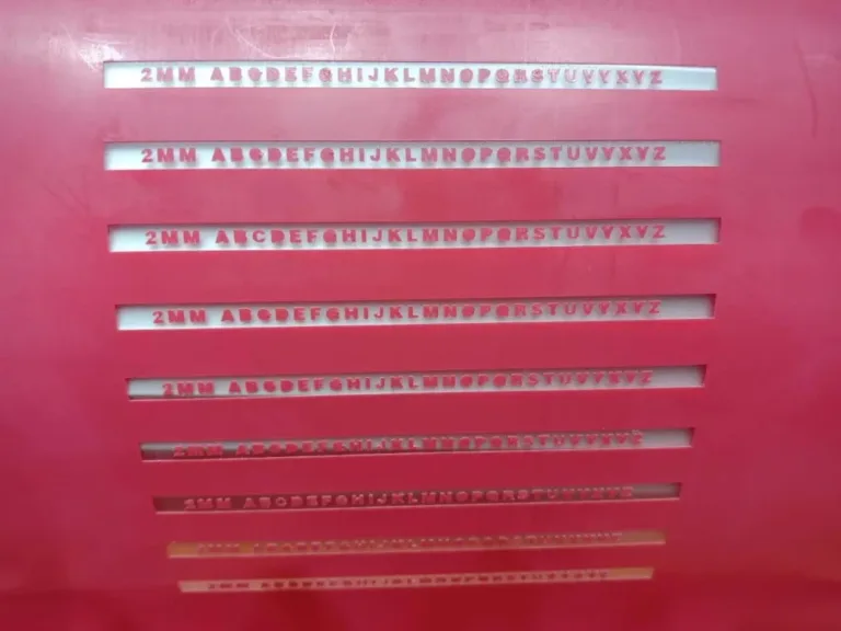 Designs of different fonts with the text '2MM ABCDEFGHIJKLMNOPQRSTUVWXYZ' engraved on a cutting board.